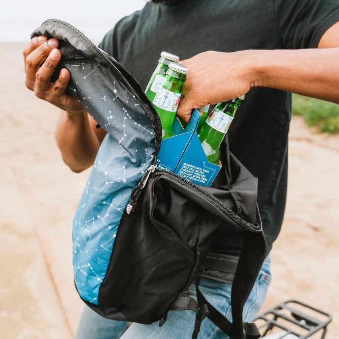 Person taking a 6 pack of drinks out of a Night Sky ChicoBag packable light weight travel pack rePETe made from recycled materials