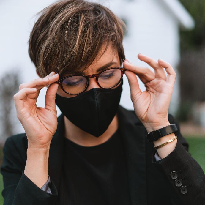 Woman with glasses wearing a ChicoBag Reusable 3-layer black mask with anti-fog.
