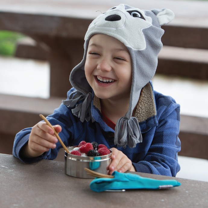 Child eating yogurt with berries with a To-Go Ware kids utensil set.