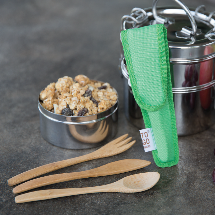 To-Go Ware Kiwi Kids packable utensil set leaning against a To-Go Ware Stainless steel tiffin.