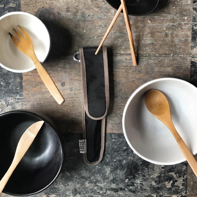 hijiki black To-Go Ware classic eco friendly bamboo utensil set case in the middle of four bowls with each of its bamboo utensils in a separate bowl